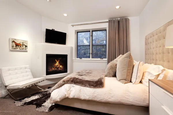 a bedroom with a bed and a fireplace