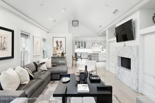 a living room with furniture a flat screen tv and a fireplace