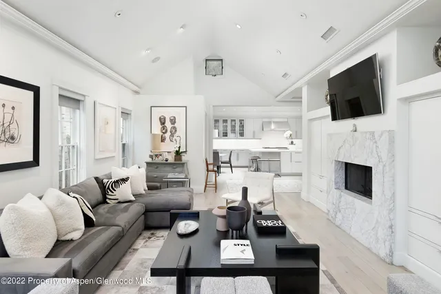 a living room with furniture a flat screen tv and a fireplace