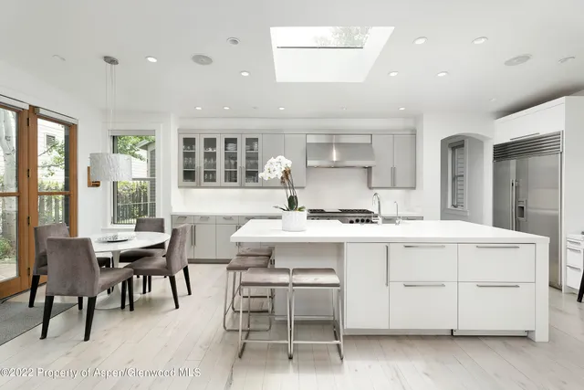 a kitchen with a sink a table and chairs in it