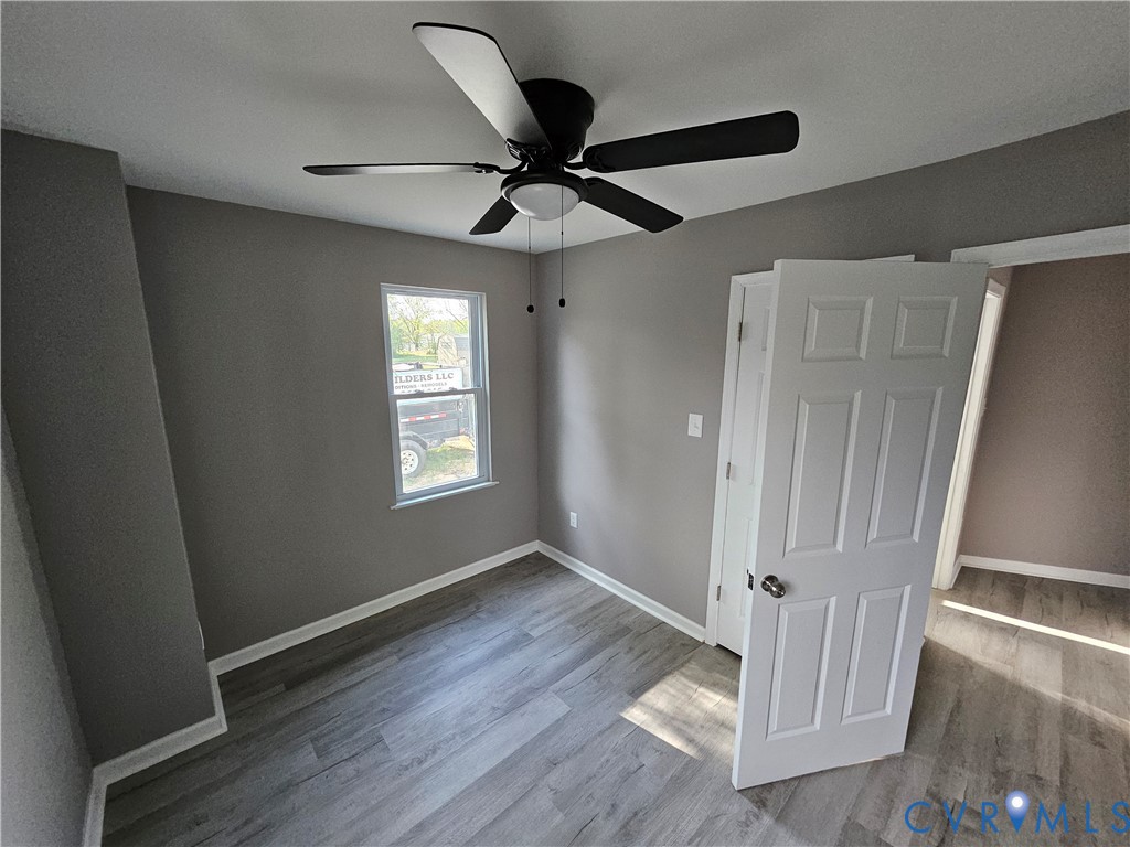 47 Ridge Road Blackstone, VA 23824 - Photo 8 of 23 an empty room with wooden floor fan and windows