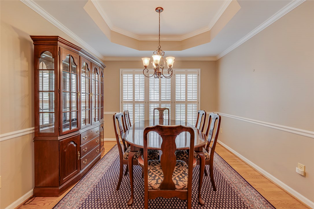 302 Wild Rice Drive Simpsonville, SC 29681 - Photo 18 of 44 Elegant crown molding and a classic tray ceiling frame this formal dining area with wood floors.