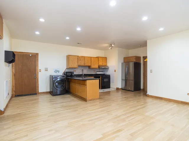 a large kitchen with stainless steel appliances a refrigerator and a stove top oven