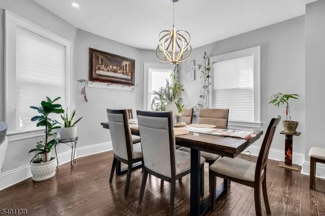 a dining room with furniture potted plants and wooden floor