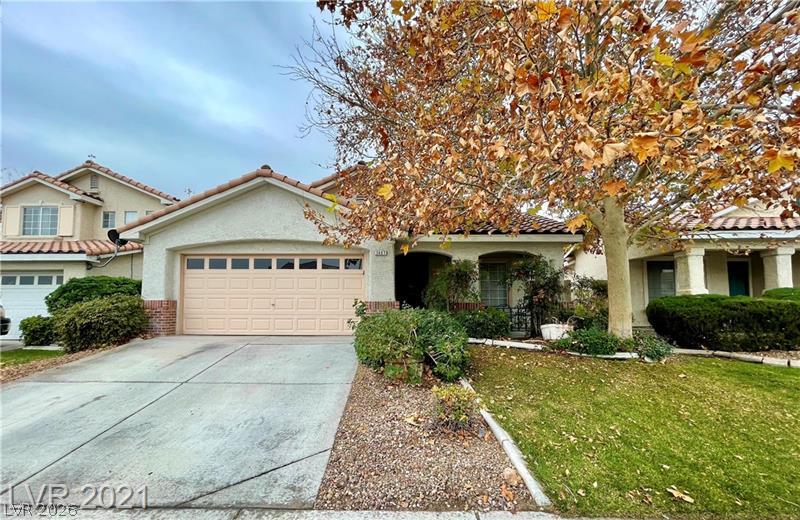 2407 Worchester Road Henderson, NV 89074 - Photo 1 of 5 A terracotta-tiled roof crowns this stucco residence, complete with an attached garage and a mature shade tree.