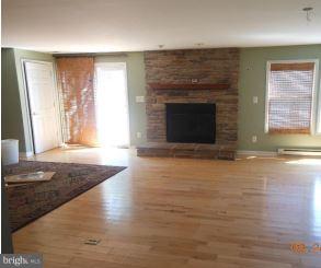 2121 Middleborough Road Baltimore, MD 21221 - Photo 7 of 10 a view of empty room with wooden floor and fireplace