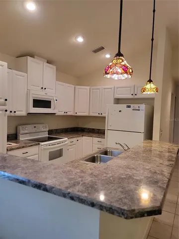 a kitchen with stainless steel appliances granite countertop a sink a stove and a microwave