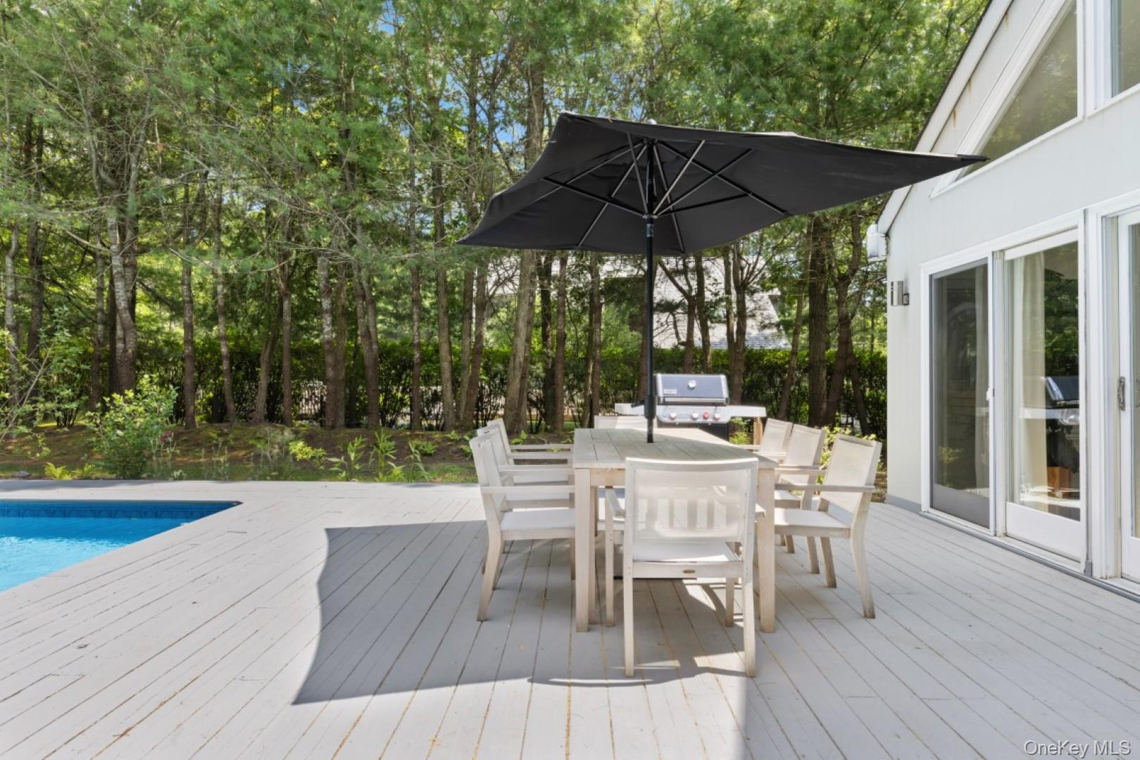 24 Quogue Riverhead Road Quogue, NY 11959 - Photo 20 of 22 a view of a dining tables and chairs under an umbrella
