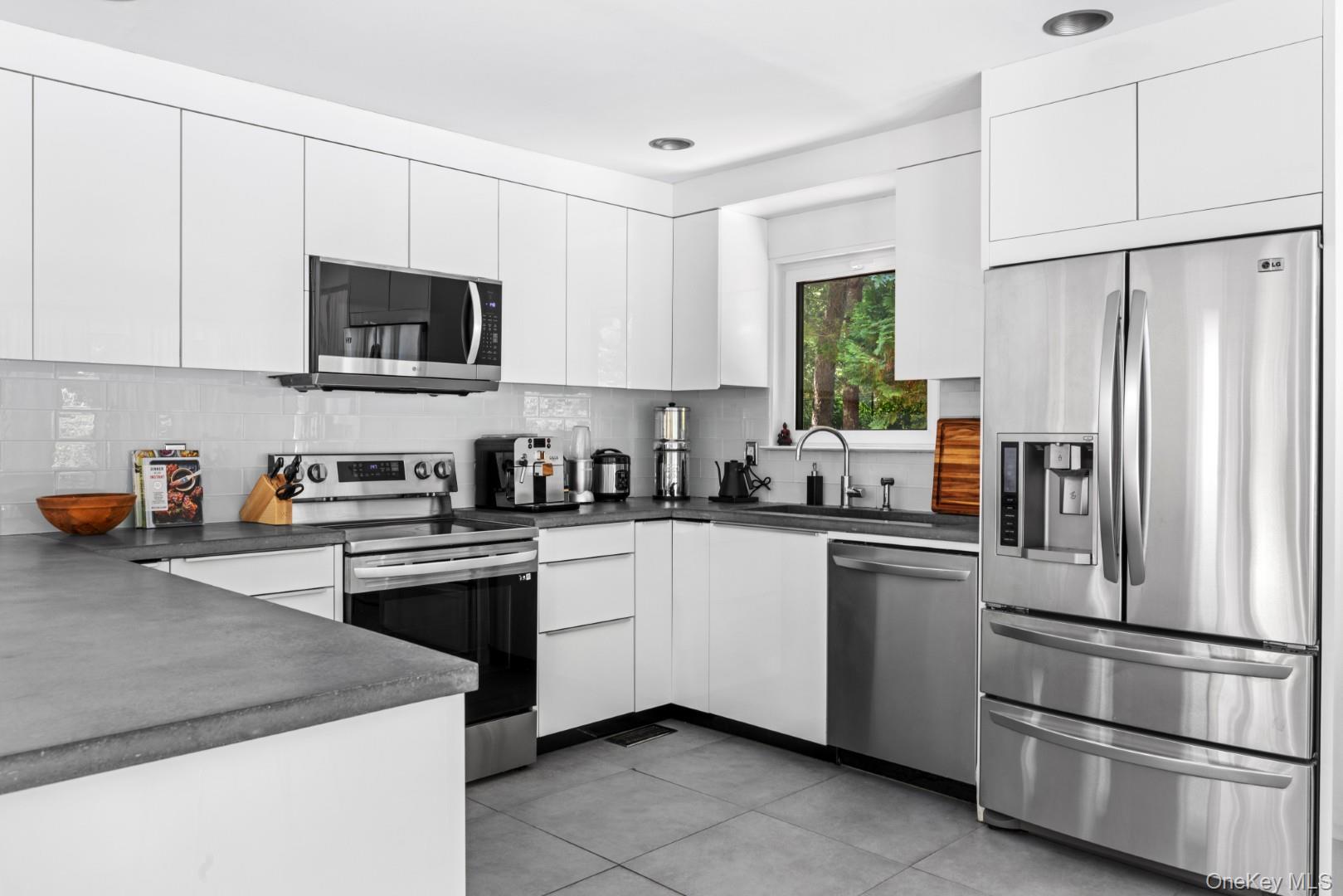 24 Quogue Riverhead Road Quogue, NY 11959 - Photo 10 of 22 a kitchen with stainless steel appliances granite countertop a refrigerator sink and microwave