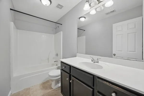 a bathroom with a sink a toilet a mirror and shower