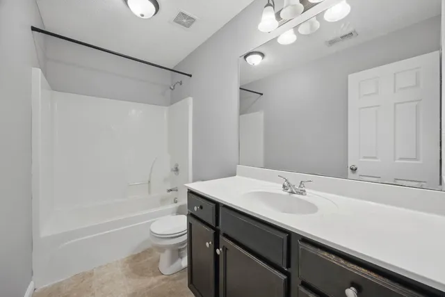 a bathroom with a sink a toilet a mirror and shower