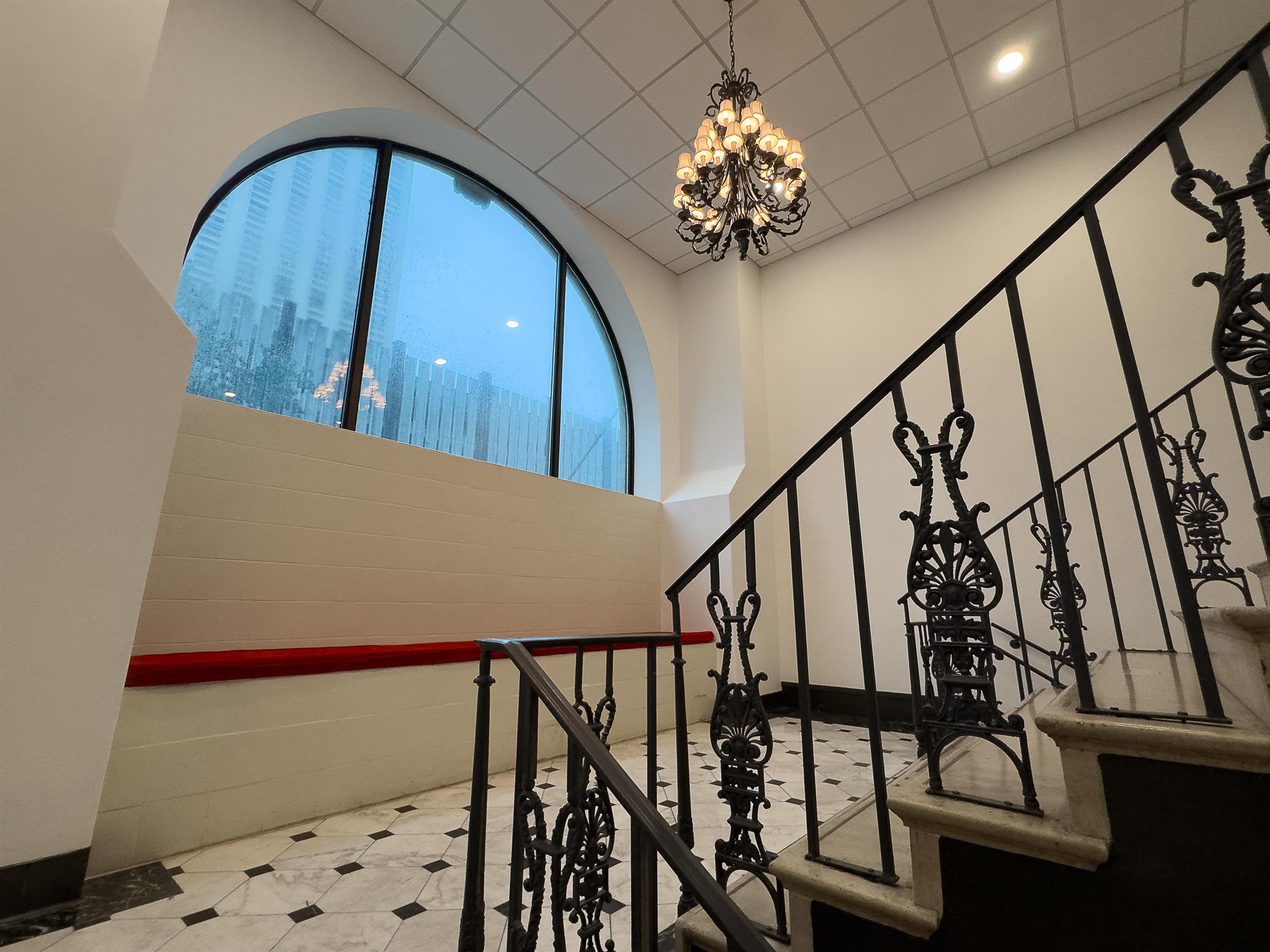 109 North Main Street, Unit 907 Memphis, TN 38103 - Photo 24 of 29 Grand staircase featuring wrought iron balusters and a polished stone tread