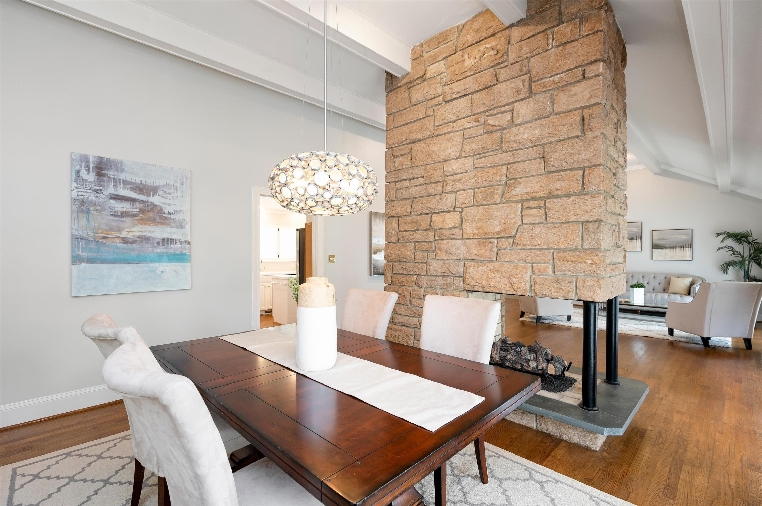 4907 Rembert Drive Raleigh, NC 27612 - Photo 9 of 52 The dining room has the same vaulted ceiling as the living room and shares the two-sided stone fireplace Dining Room
