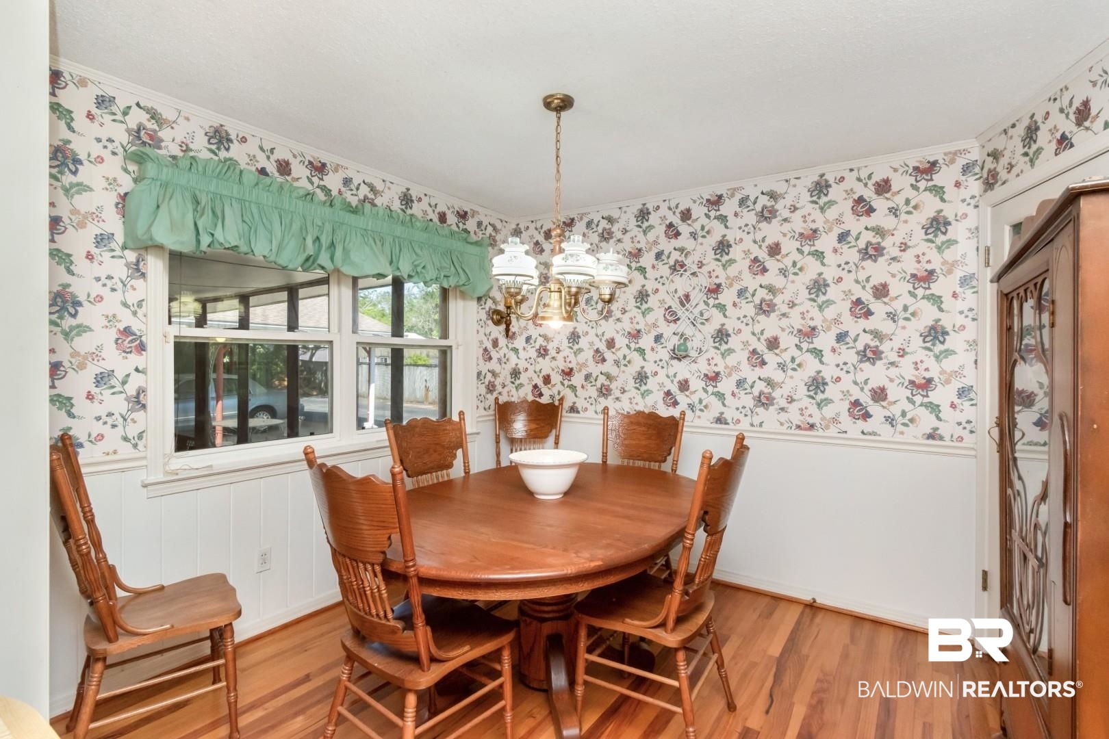 6300 Woodcrest Drive Mobile, AL 36608 - Photo 13 of 35 Dining room featuring light wood-style flooring, wallpapered walls, and wainscoting