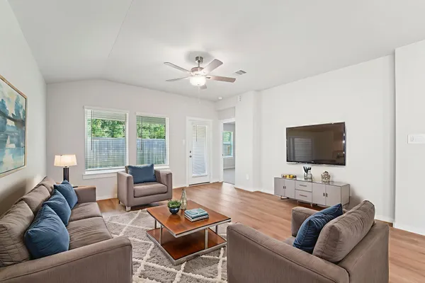 a living room with furniture and a flat screen tv with wooden floor