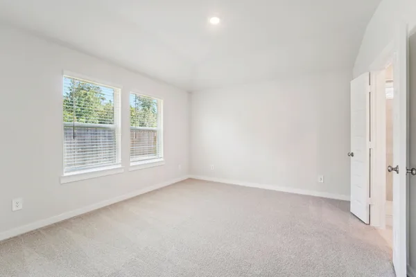 a spacious bedroom with a bed and a window