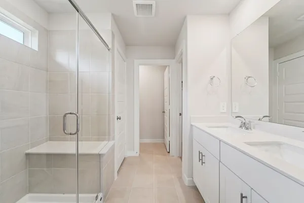 a bathroom with a double vanity sink mirror and shower
