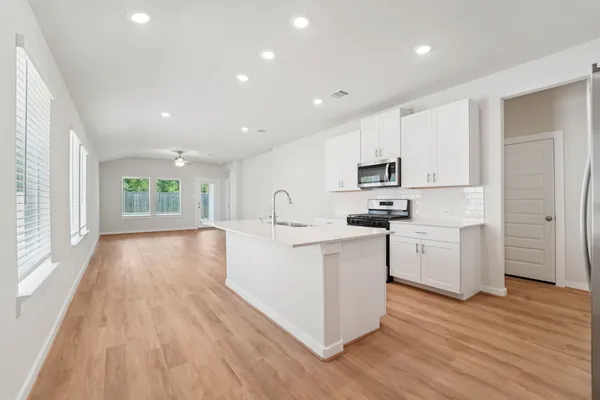 a kitchen with sink a wooden floor and large window