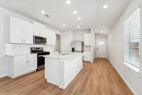 a kitchen with white cabinets and stainless steel appliances