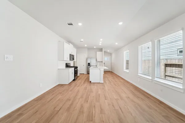 a view of a kitchen with wooden floor and windows