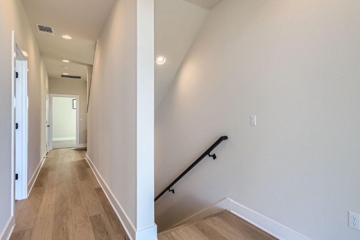 9101 Cattle Baron Path Austin, TX 78747 - Photo 12 of 29 a view of a hallway with wooden floor and staircase