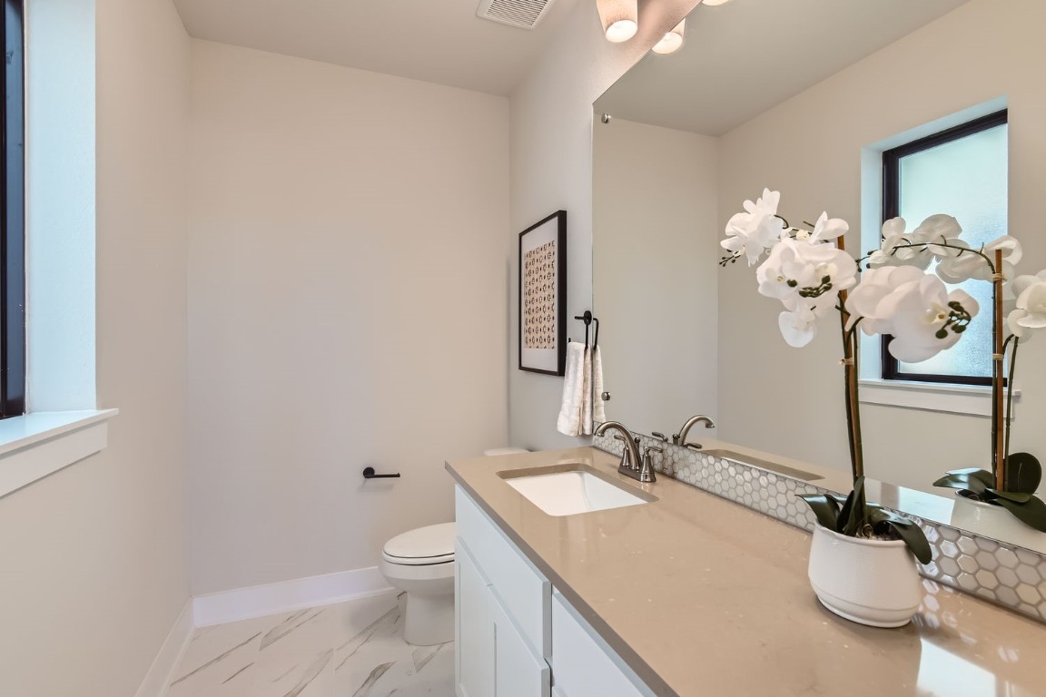9101 Cattle Baron Path Austin, TX 78747 - Photo 6 of 29 a bathroom with a granite countertop sink a toilet and a mirror