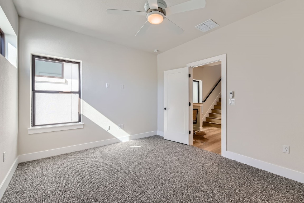 9101 Cattle Baron Path Austin, TX 78747 - Photo 10 of 29 an empty room with chandelier fan and windows