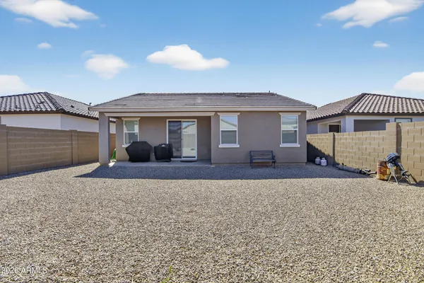 a view of a house with a patio and a yard