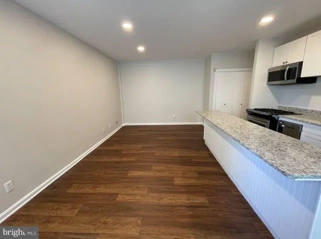 a kitchen with granite countertop a sink and steel appliances