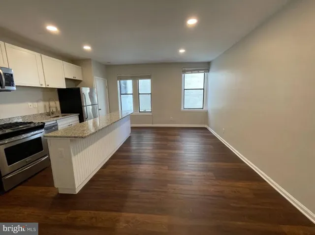 a view of kitchen with microwave stove refrigerator and cabinets