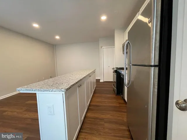 a view of a refrigerator in kitchen and wooden floor