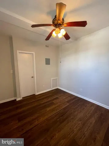 a view of room with wooden floor fan and window