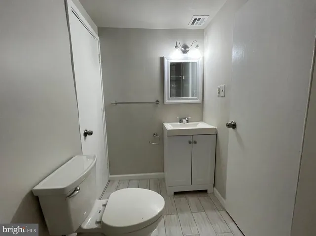 a bathroom with a toilet sink and mirror