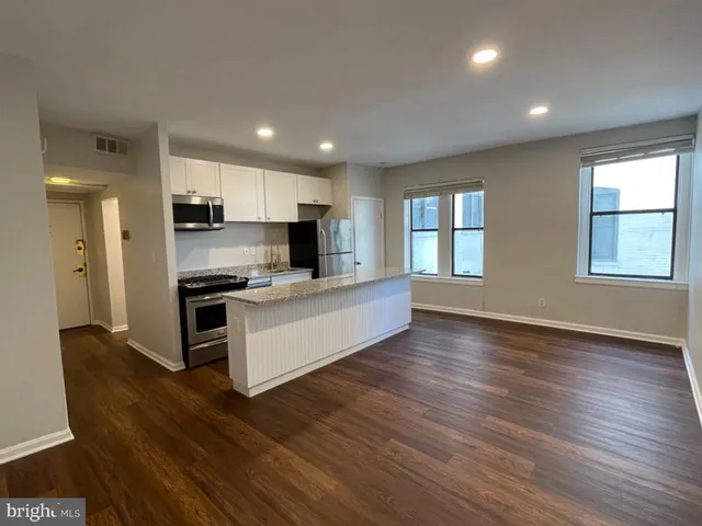 a kitchen with stainless steel appliances kitchen island wooden cabinets and granite counter tops