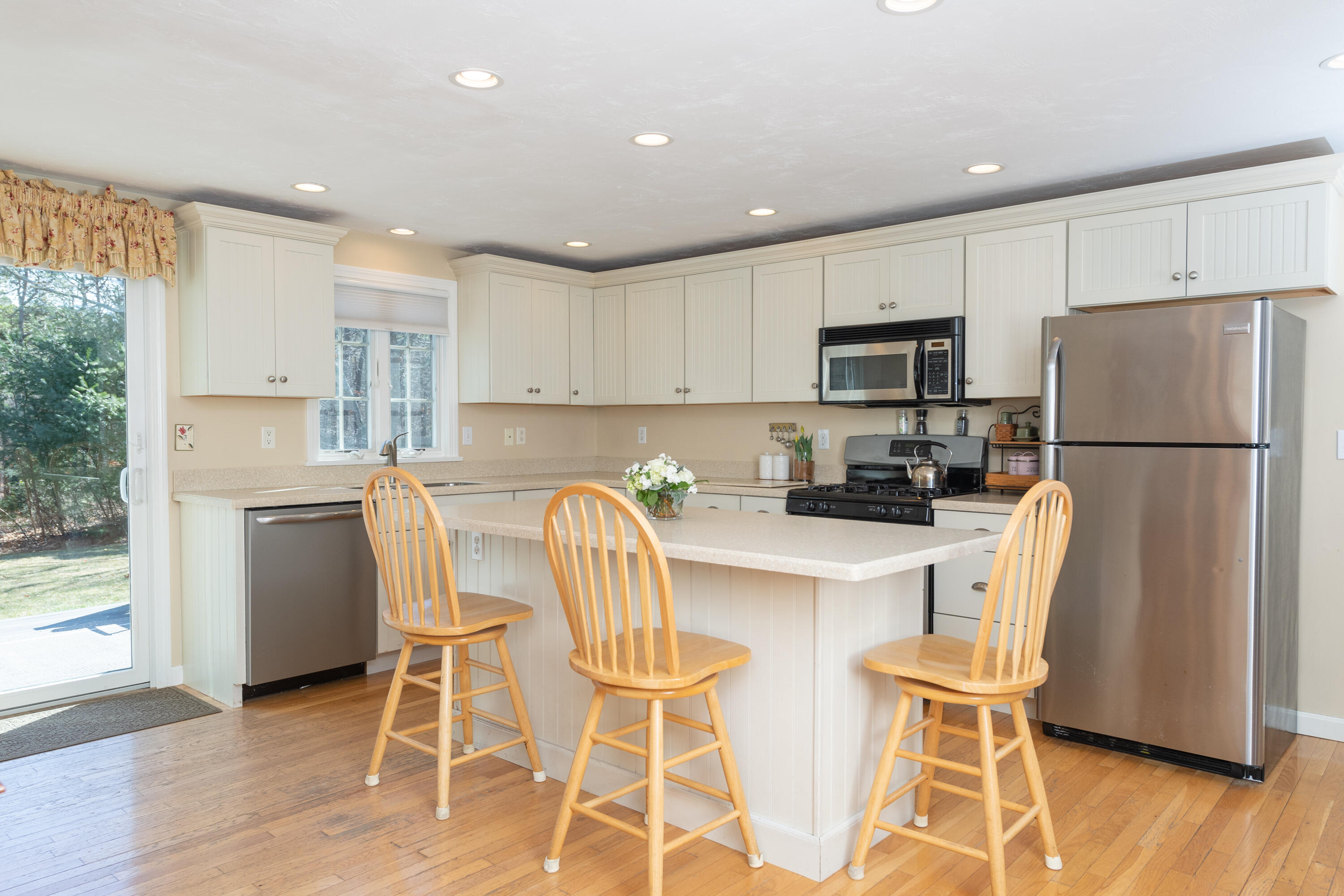 19 Carleton Drive Mashpee, MA 02649 - Photo 13 of 45 a kitchen with stainless steel appliances a refrigerator a stove top oven and a center island with wooden floor