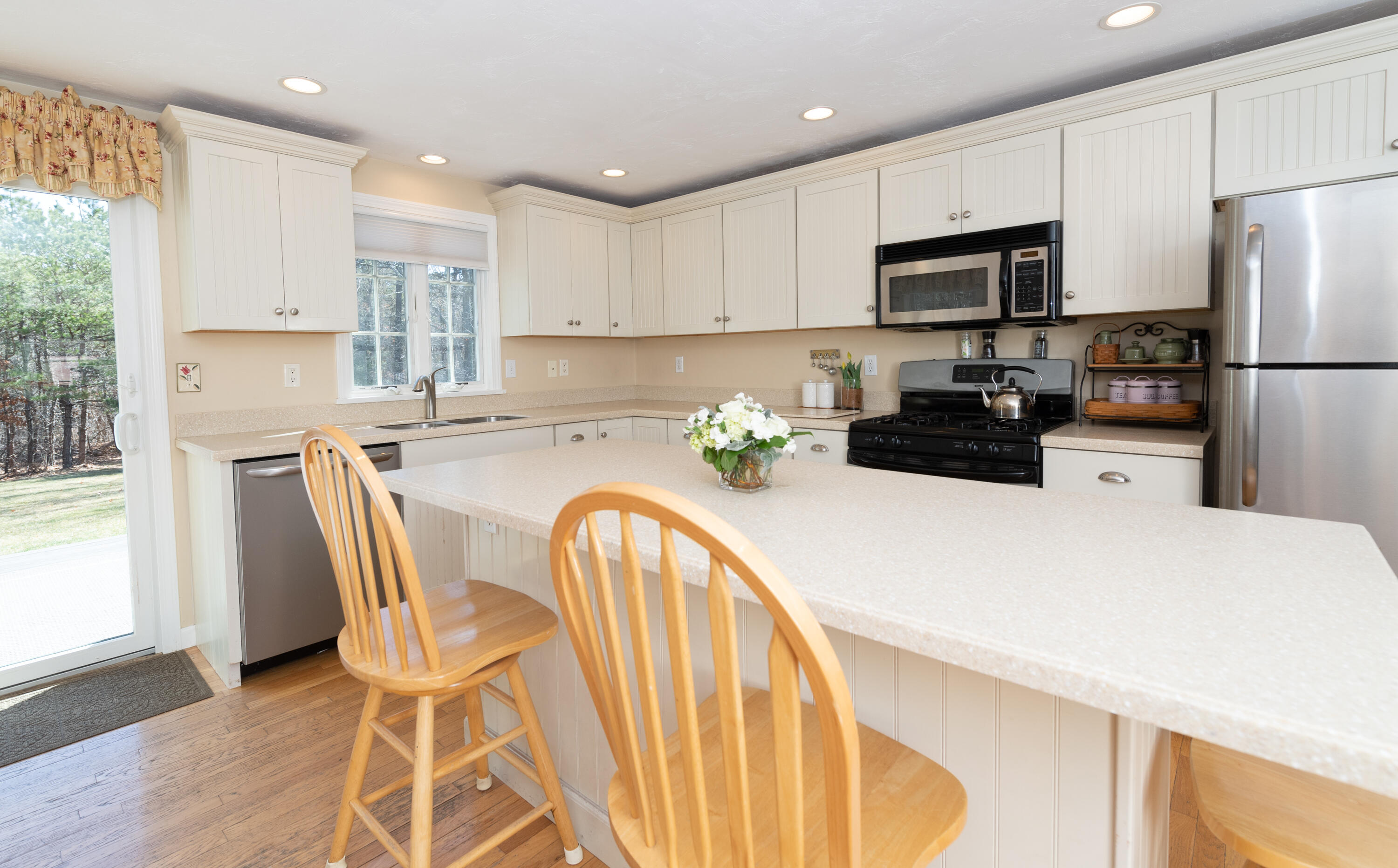 19 Carleton Drive Mashpee, MA 02649 - Photo 14 of 45 a kitchen with stainless steel appliances granite countertop a refrigerator a stove top oven a sink dishwasher and white cabinets with wooden floor