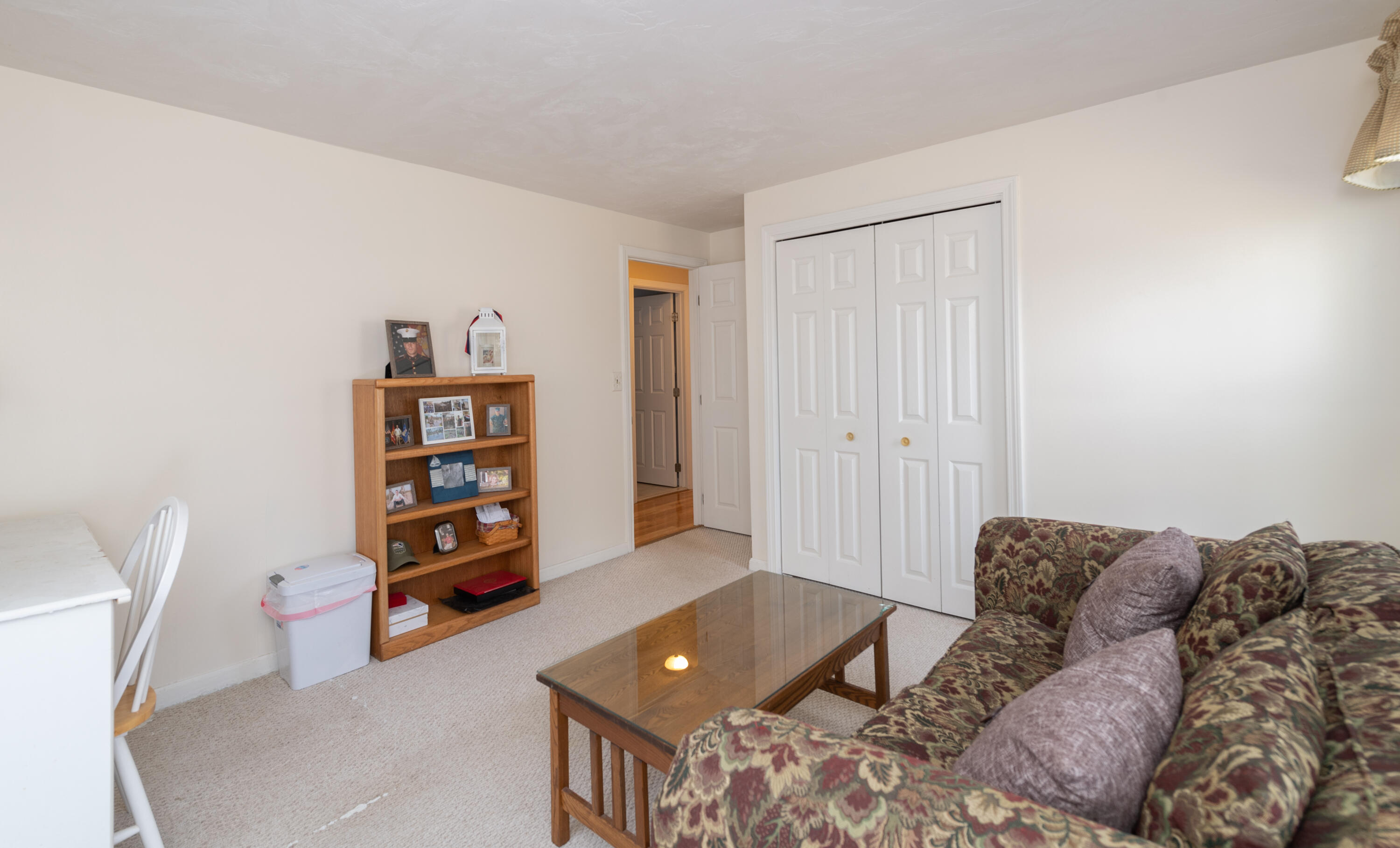 19 Carleton Drive Mashpee, MA 02649 - Photo 22 of 45 a living room with furniture and a book shelf