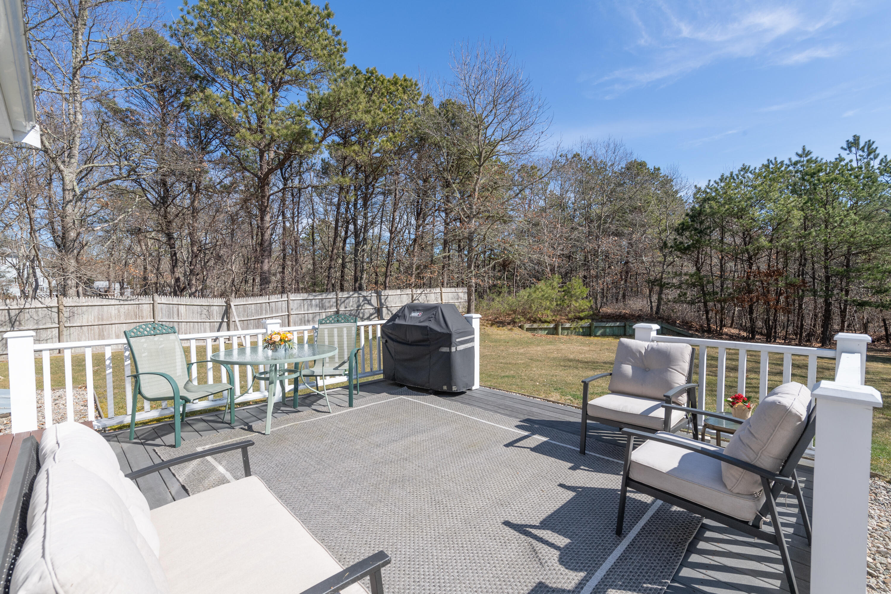 19 Carleton Drive Mashpee, MA 02649 - Photo 36 of 45 a roof deck with couches and wooden fence