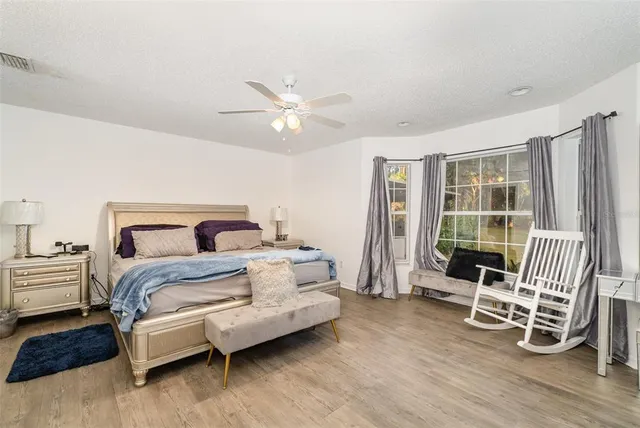 a spacious bedroom with a bed a table and chair