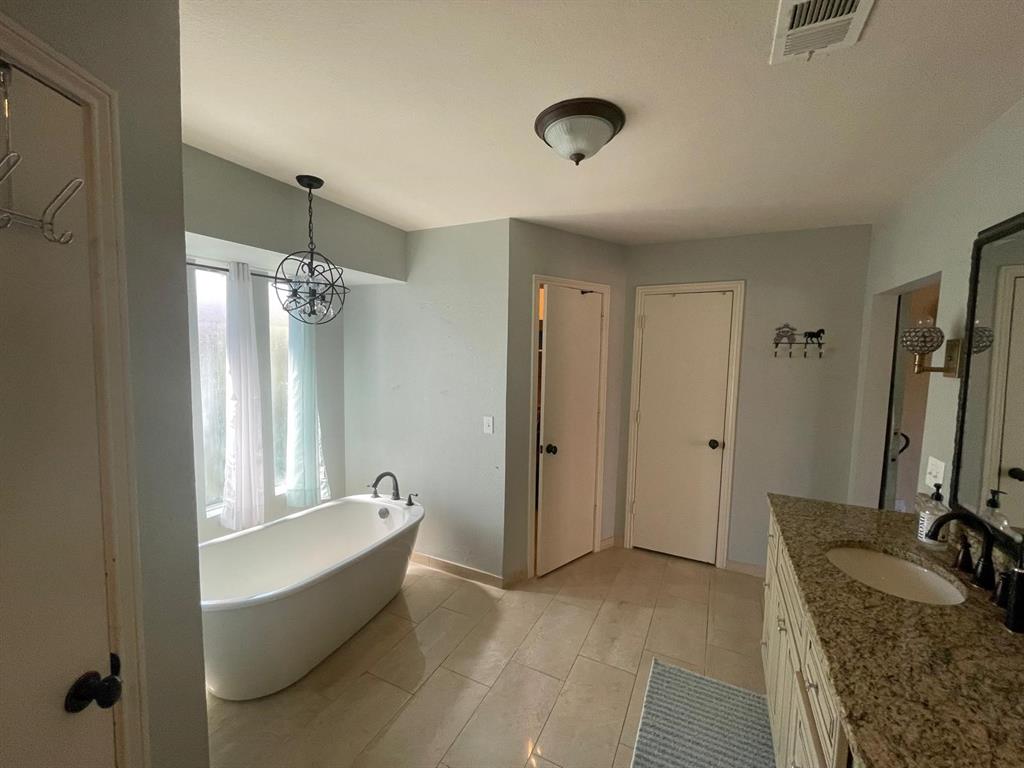 3612 Cross Bend Road Plano, TX 75023 - Photo 28 of 38 Bathroom with a bath to relax in, a notable chandelier, tile floors, and large vanity