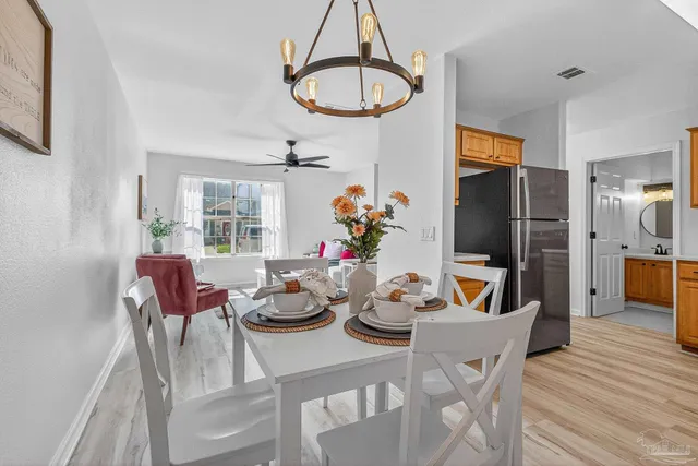 a view of a dining room with furniture a chandelier and wooden floor