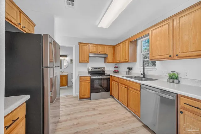 a kitchen with stainless steel appliances granite countertop a refrigerator sink and cabinets