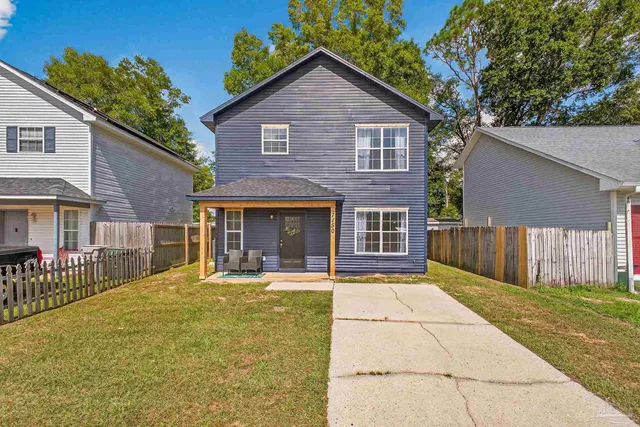 a front view of a house with a yard outdoor seating and garage