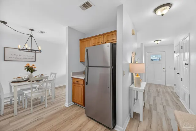 a kitchen with granite countertop a refrigerator and a wooden floor