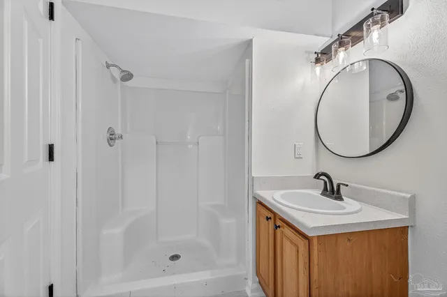 a bathroom with a sink a mirror and a shower