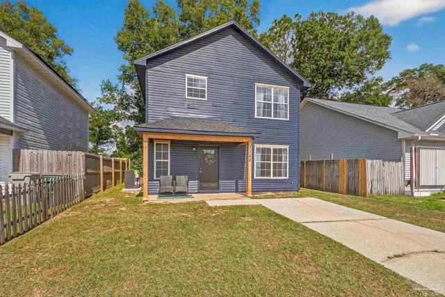 a front view of a house with a yard outdoor seating and garage