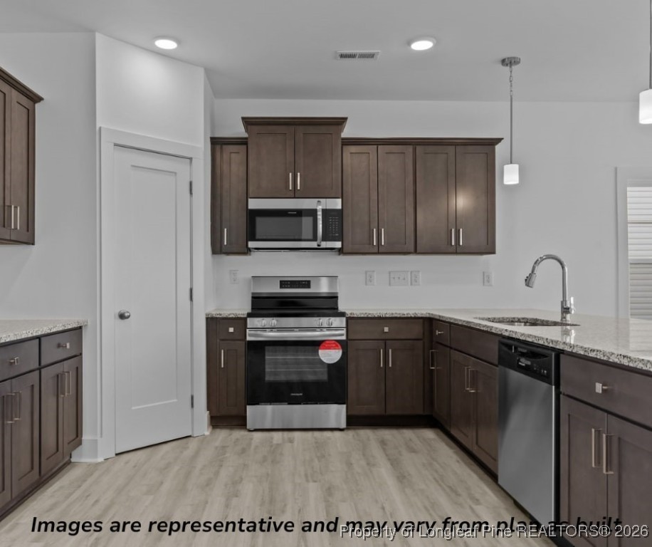 9864 Rockfish Road Raeford, NC 28376 - Photo 6 of 9 a kitchen with stainless steel appliances granite countertop a sink stove and microwave