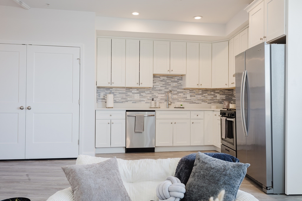 92-94 George Street, Unit 203 Boston, MA 02119 - Photo 12 of 35 a kitchen with stainless steel appliances granite countertop a refrigerator sink and cabinets