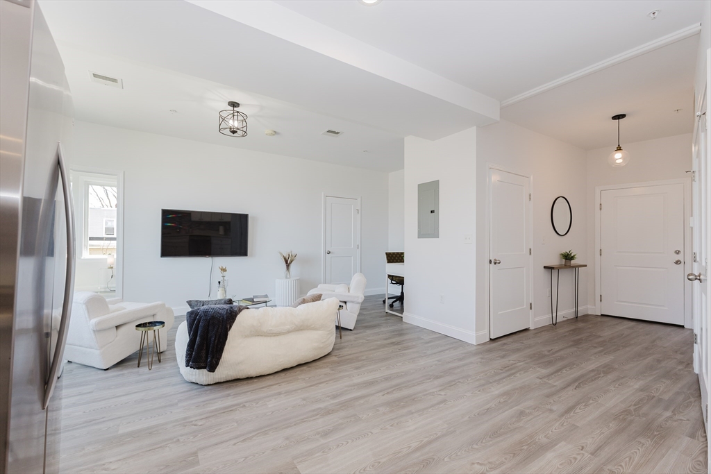 92-94 George Street, Unit 203 Boston, MA 02119 - Photo 2 of 35 a spacious bedroom with a bed and a flat screen tv