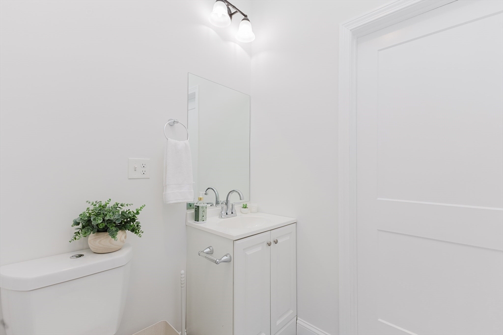 92-94 George Street, Unit 203 Boston, MA 02119 - Photo 22 of 35 a bathroom with a sink toilet and vanity